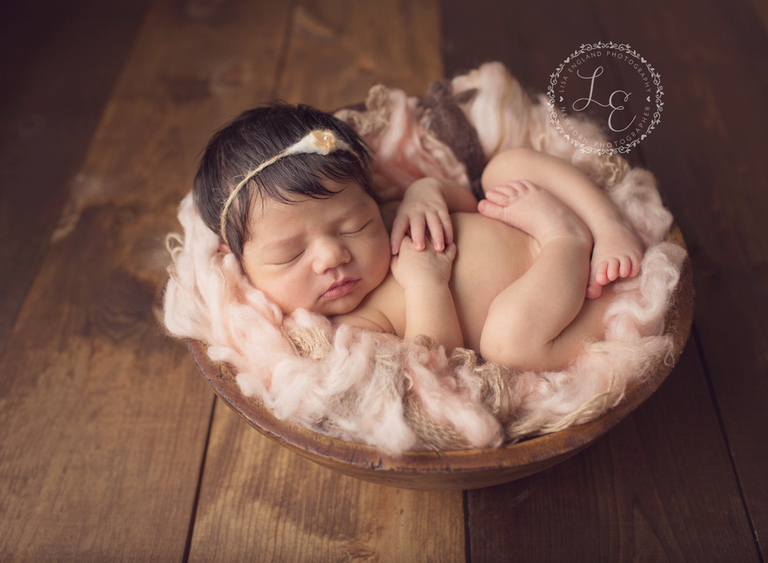 baby girl sleeping in a bowl