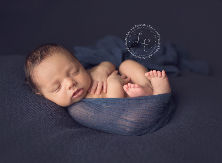 newborn boy snuggled in blue