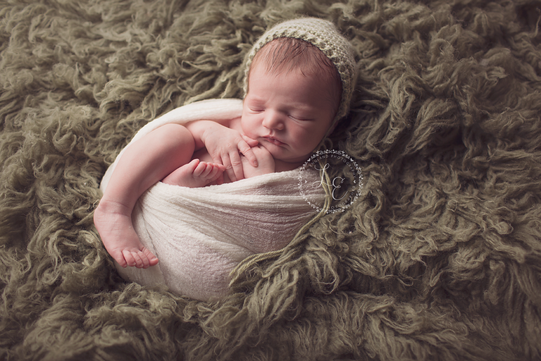 infant boy on green rug
