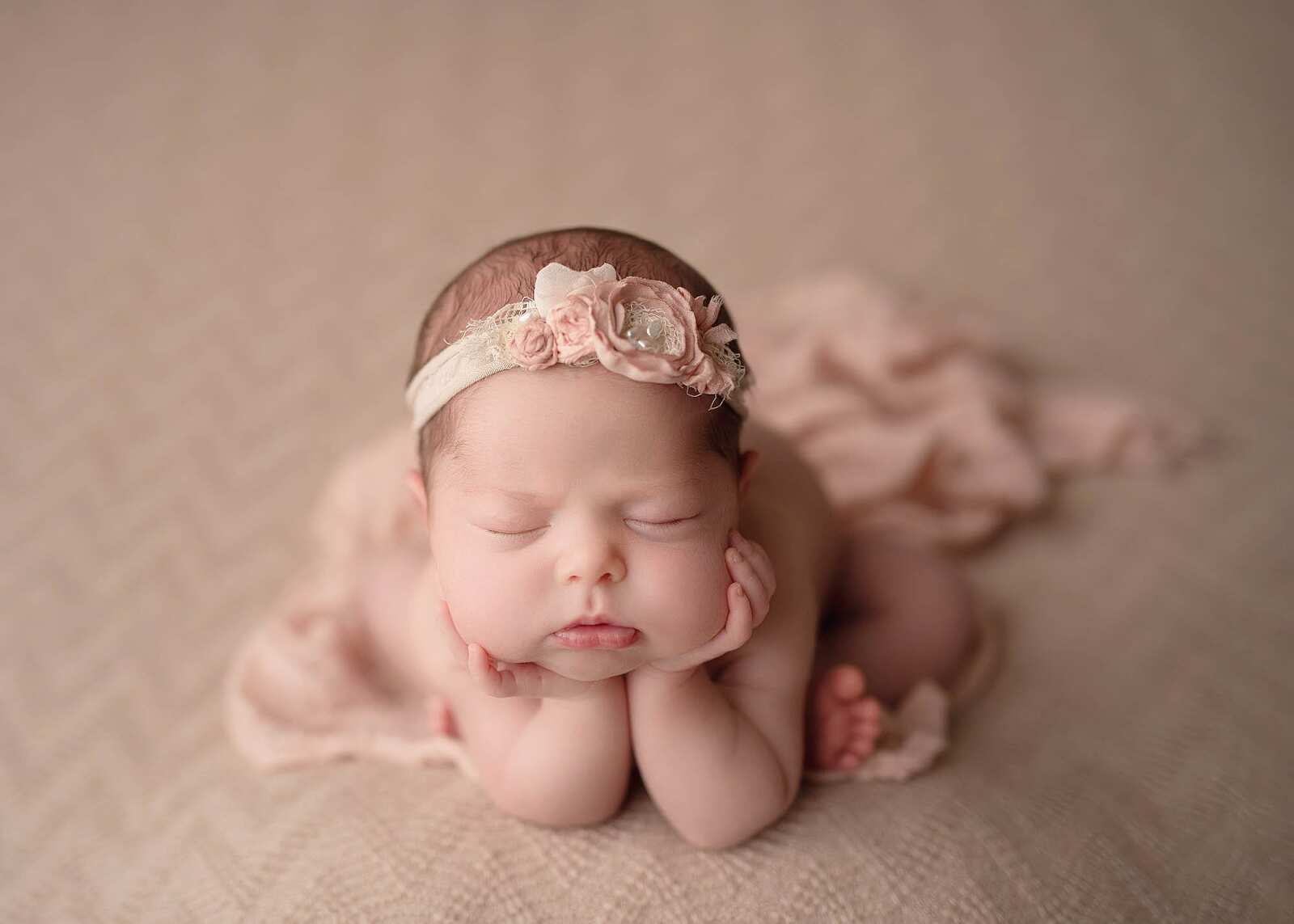 baby girl in the froggy pose wearing a floral headband