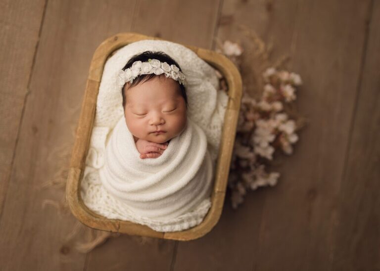 timeless, heartfelt portrait of a newborn girl sleeping in a basket