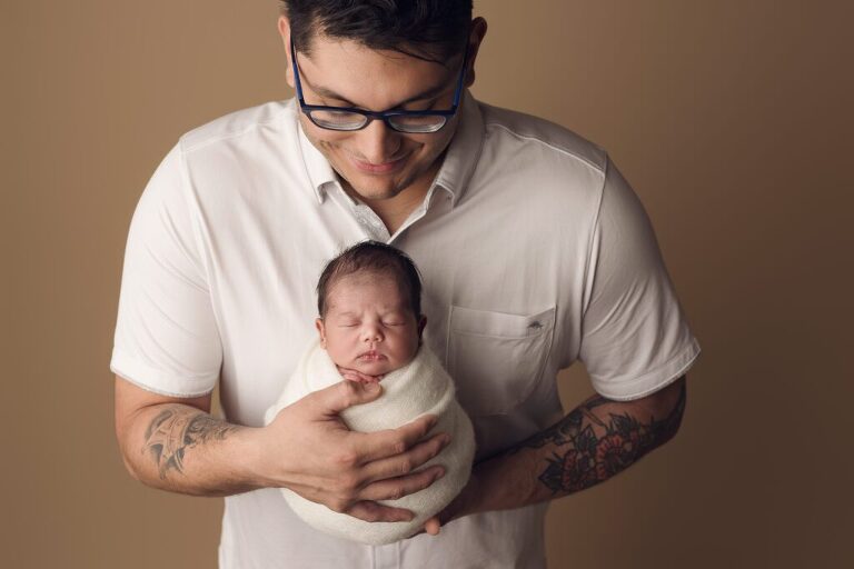 Dad holding his new baby girl during her newborn session in San Diego