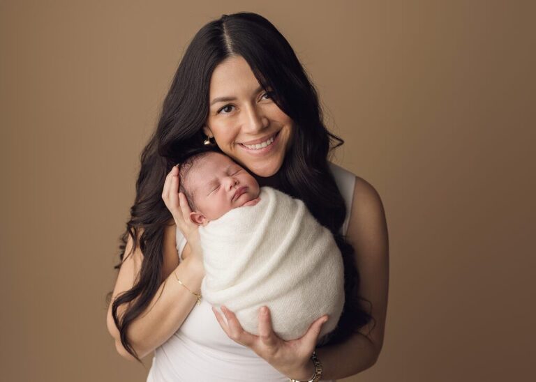 Mom holding her baby during a softly posed newborn session in San Diego