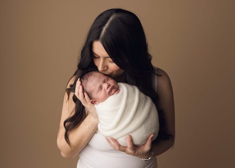 Mom giving her baby girl kisses during her session in San Diego