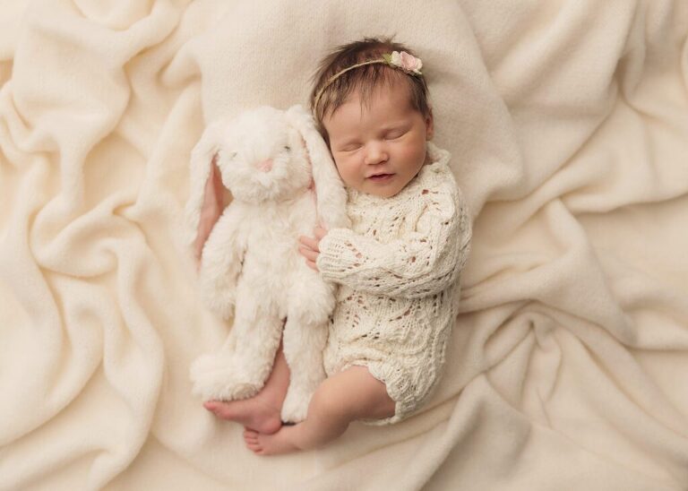 newborn girl cuddling a stuffed bunny toy, san diego newborn photography studio