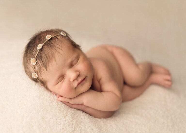 precious newborn baby girl sleeping peacefully in a sidelying pose, san diego newborn photography studio