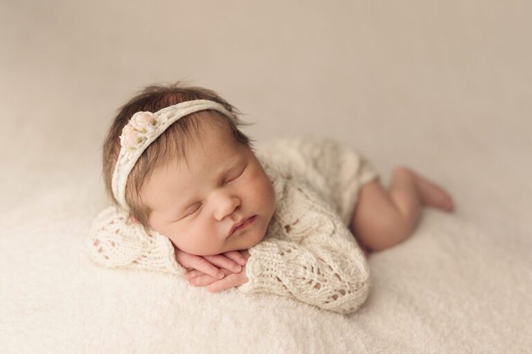 newborn baby girl asleep wearing a cream knit outfit, san diego newborn photography studio