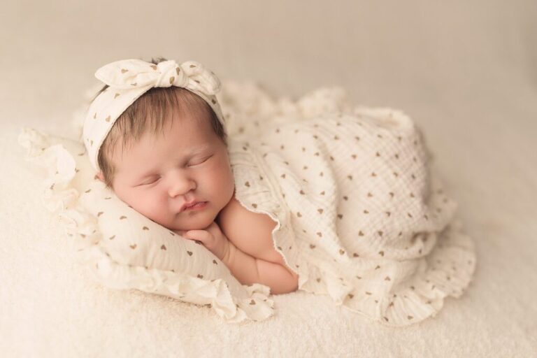 cutest newborn baby girl sleeping on a pillow with a matching blanket and headband, san diego newborn photography studio