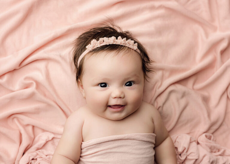 Smiling three month old baby photographed by a San Diego baby photographer